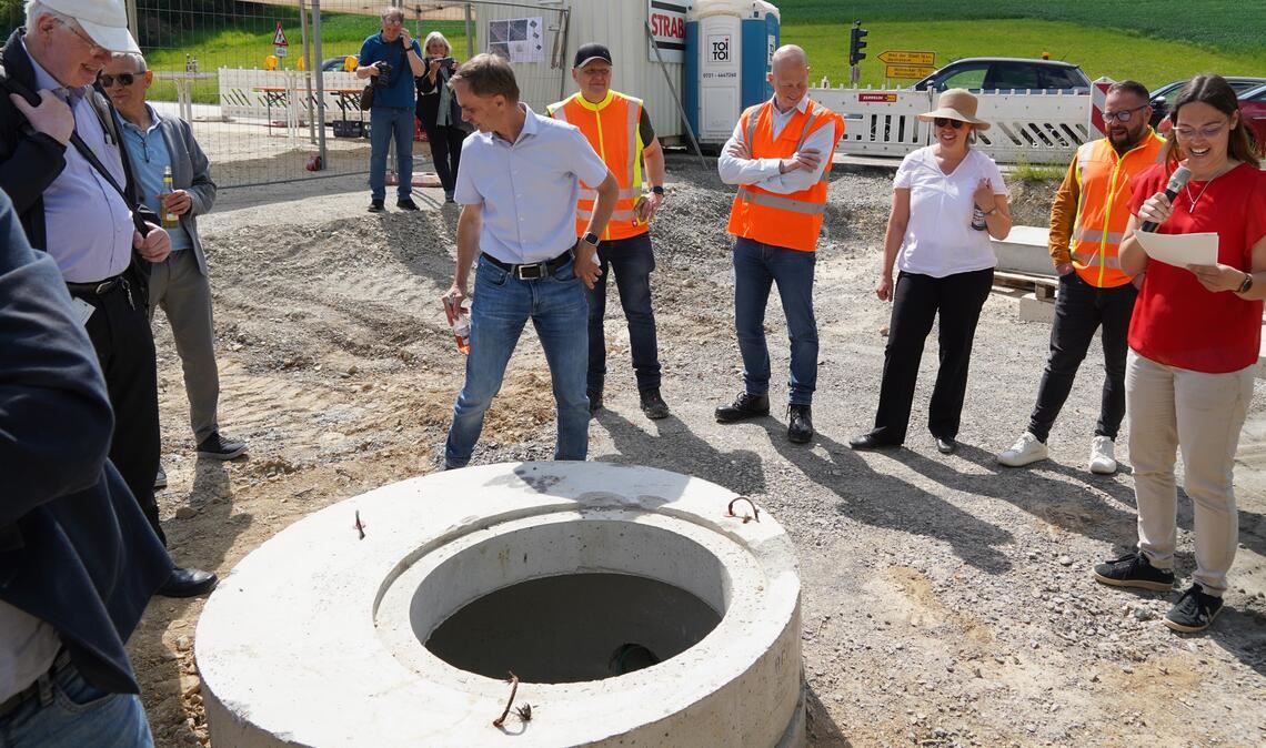 Im Untergrund der neuen „Porsche-Straße“ befindet sich bereits ein Stauraumkanal. Sandy Hillbrecht (re.) klärt beim Ortstermin über den Baufortschritt auf. Foto: Roller