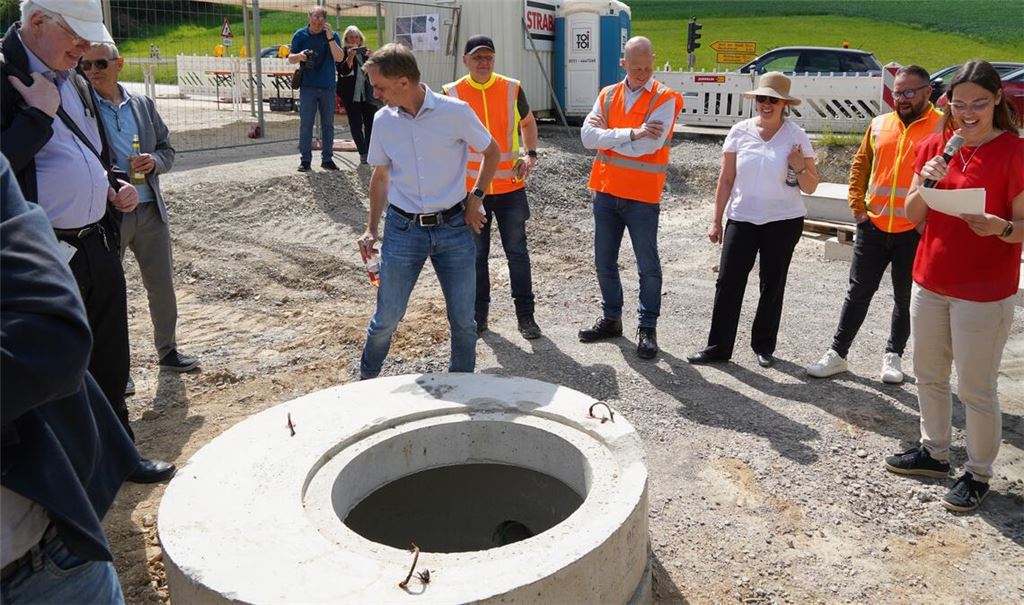 Im Untergrund der neuen „Porsche-Straße“ befindet sich bereits ein Stauraumkanal. Sandy Hillbrecht (re.) klärt beim Ortstermin über den Baufortschritt auf. Foto: Roller