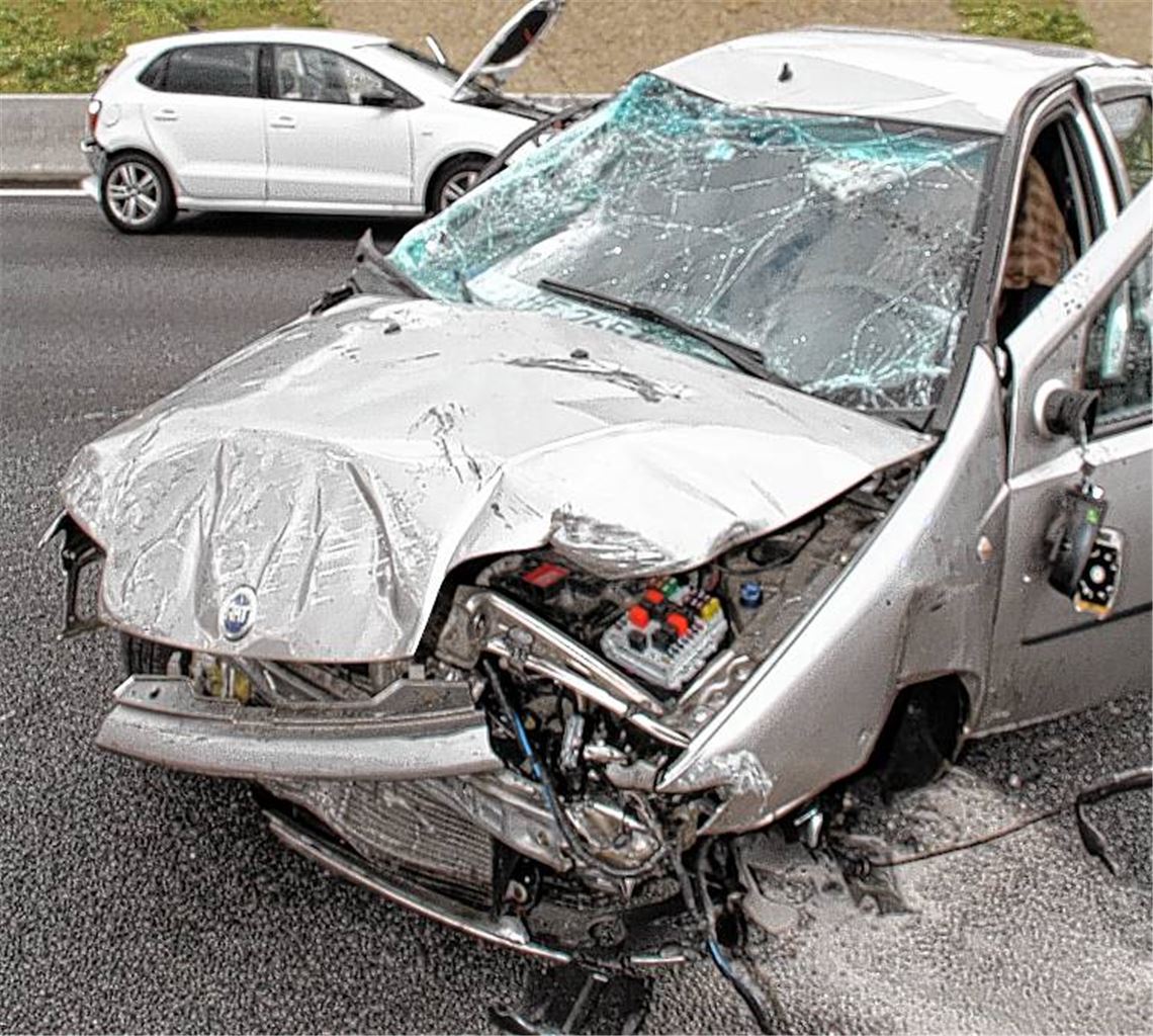 Im Vordergrund eines von drei demolierten Autos nach dem Unfall auf der Autobahn. 