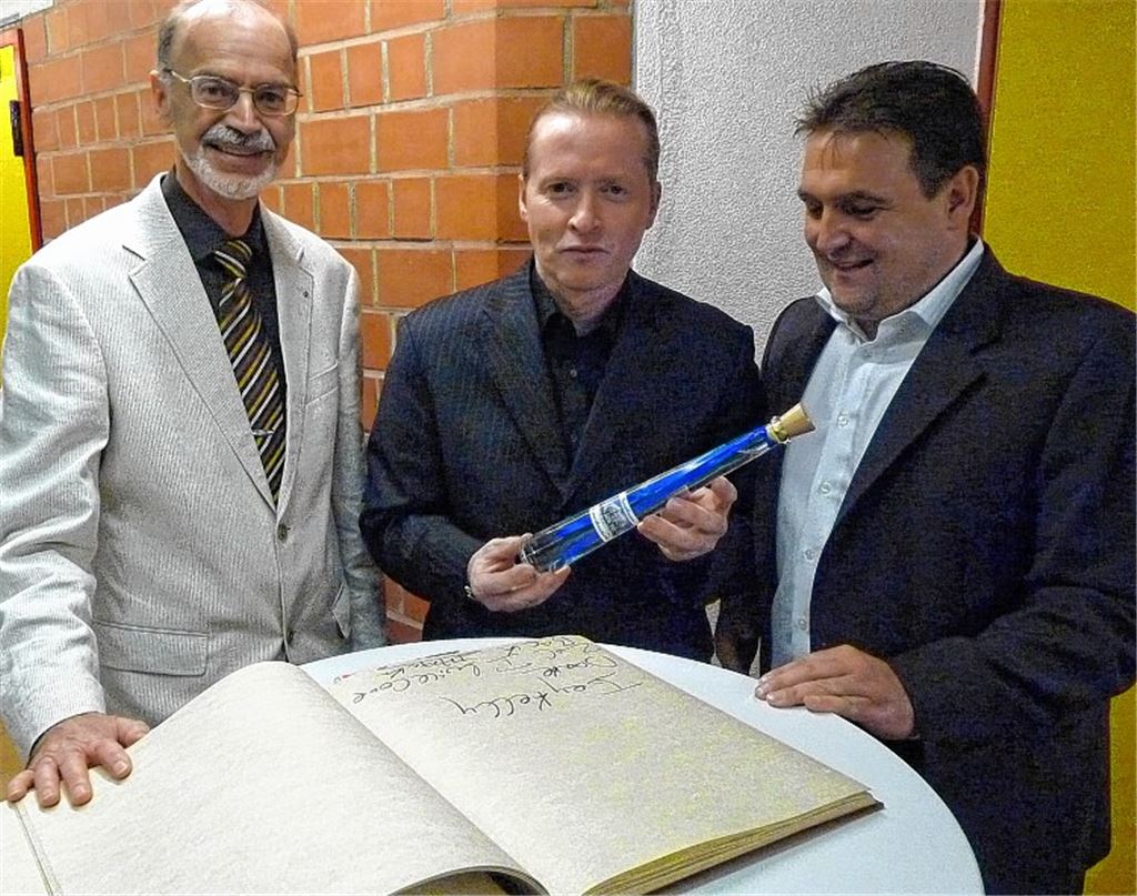 Immer locker: Nach ein paar Kilometern Jogging durch Kieselbronn trägt sich der Extrem- und Ausnahmesportler Joey Kelly (M.), flankiert von Bernd Elfner vom Turnverein Kieselbronn (li.) und Bürgermeister Heiko Faber, ganz entspannt ins Goldene Buch der Gemeinde ein. 