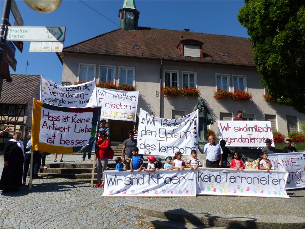 In Knittlingen beziehen Flüchtlinge, darunter auch Familien mit Kindern, bei einer kleinen Kundgebung vor dem Rathaus klar Stellung gegen Gewalt und Terror.  Foto: privat