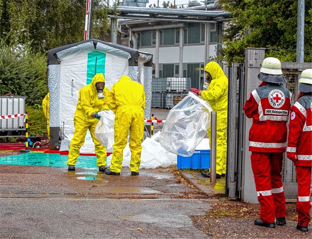 In Schutzanzügen geht die Feuerwehr ans Werk.