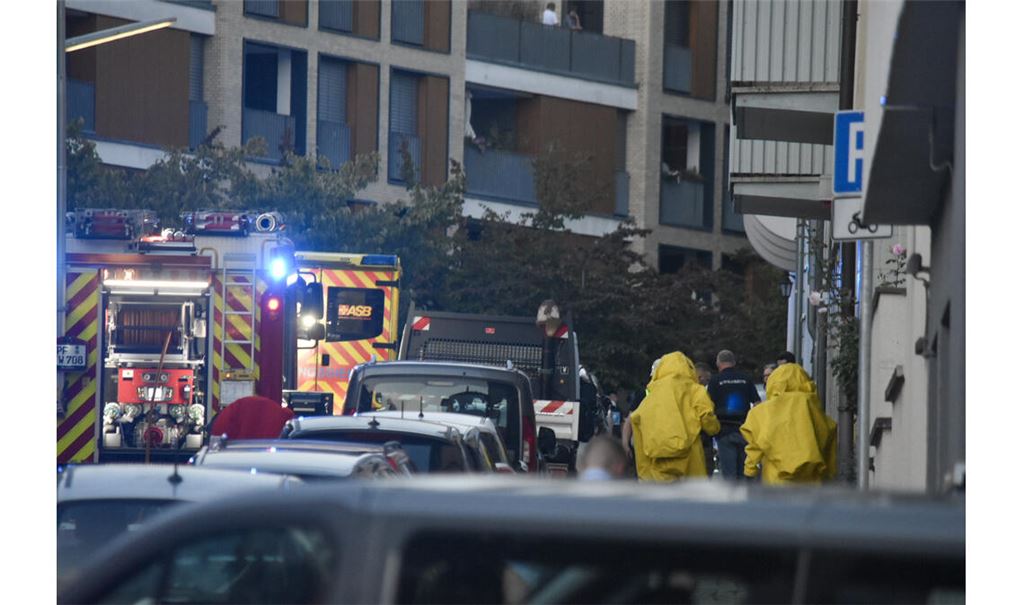 In Schutzanzügen nähern sich Einsatzkräfte der betroffenen Wohnung. Foto: myro