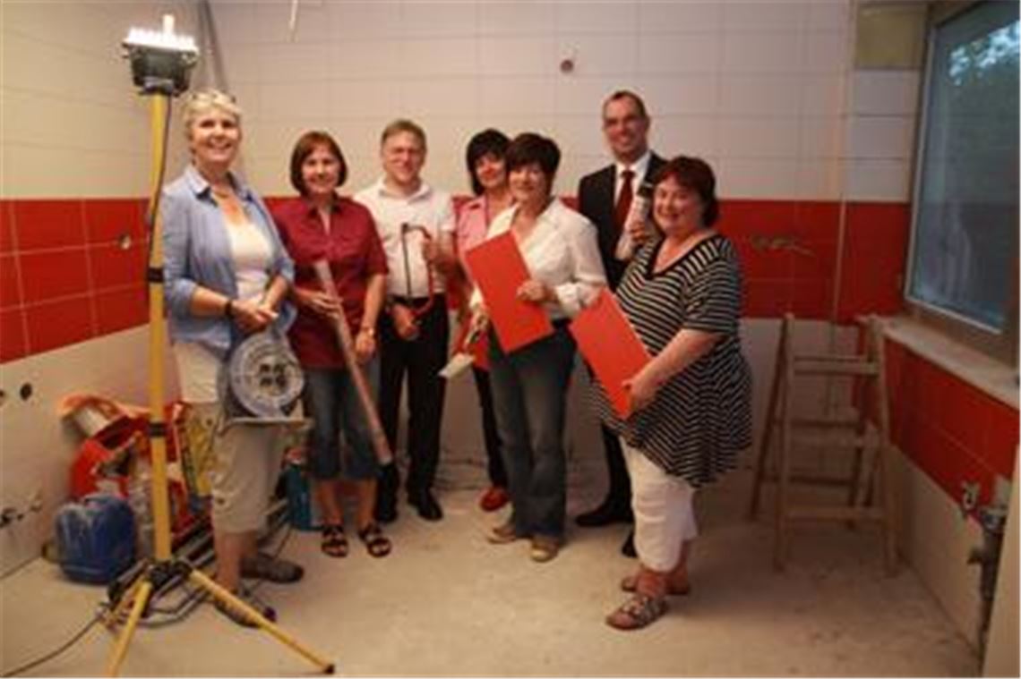 In der künftigen Küche (v. li.) Ute Beierle und Carmen Olt, Leiterinnen der Betreuungseinrichtung Rabennest, Bildungs- und Kulturamtsleiter Richard Cassutti, Sabine Kistner-Brenner (Kassiererin des Rabennest e. V.), Erste Vorsitzende Sabine Albrecht, Oberbürgermeister Frank Schneider und Karin Lutz, ebenfalls Mitglied des Leitungsteams. 
Foto: Sadler