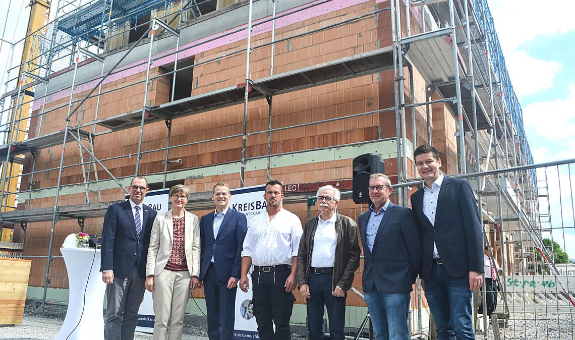 In diesem Neubau an der Breslauer Straße 7 in Mühlacker sollen ab Herbst dieses Jahres neun Mietwohnungen bezugsfertig sein. Darüber freuen sich beim Richtfest der KreisBau Enz-Neckar Mühlackers Oberbürgermeister Frank Schneider (v.li.), die vbw-Vorstandsdirektorin Dr. Iris Beuerle, KreisBau-Vorstand Holger Schünhof, Zimmerermeister Sascha Albrecht, Architekt Hans Fauth, KreisBau-Vorstand Johannes Altmann und Bauleiter Sebastian Boger. Fotos: Stahlfeld
