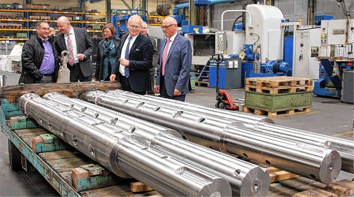 In höchster Präzision werden bei Händle Stahlwellen auf Maß gebracht, zeigt Geschäftsführer Gerhard Fischer (re.) Landrat Karl Röckinger. Links im Bild lässt sich Konrad Teufel vom Grundstücksmanagement der Stadt Mühlacker von Händle-Prokurist Andreas Treut informieren.