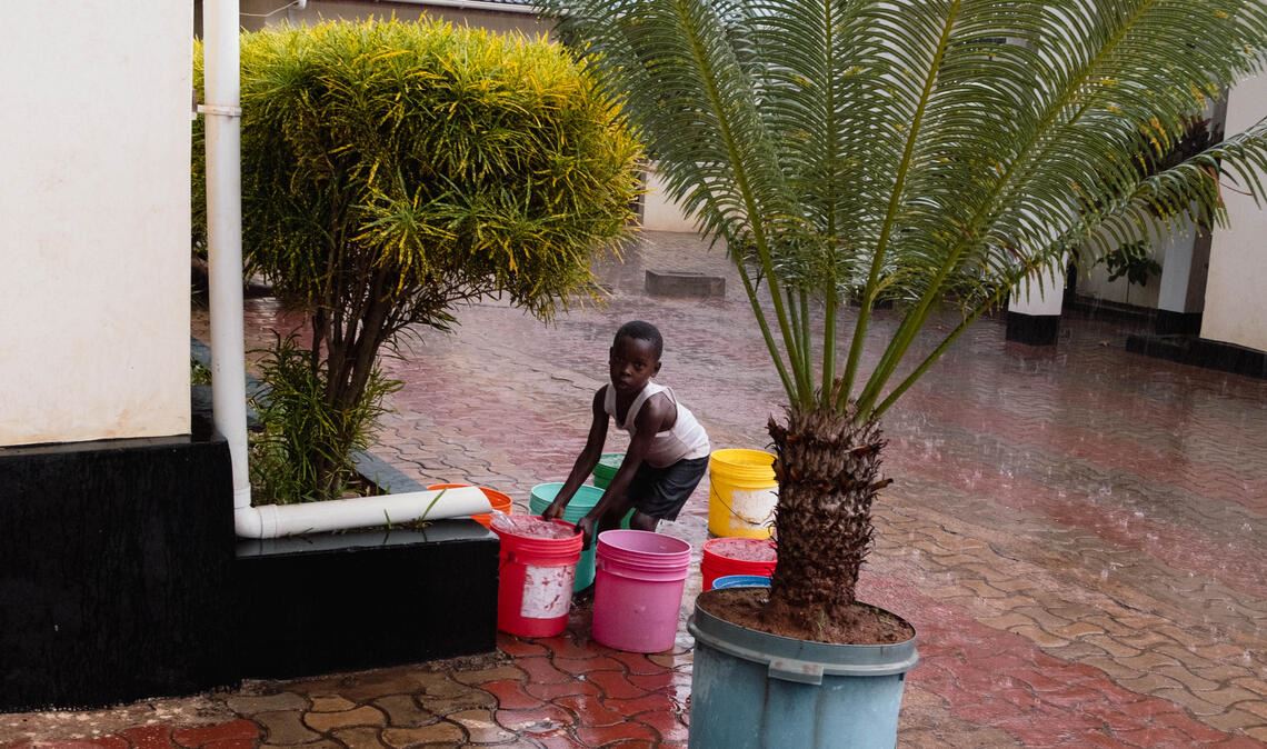 In wenigen Häusern sind Regenrinnen montiert, diese enden aber dann ohne große Auffangmöglichkeit. Bei der Lamboni Lodge, die an die öffentliche Wasserversorgung angeschlossen ist, sammeln die Nachbarn das Regenwasser in Eimern. Foto: Melissa Gewiese