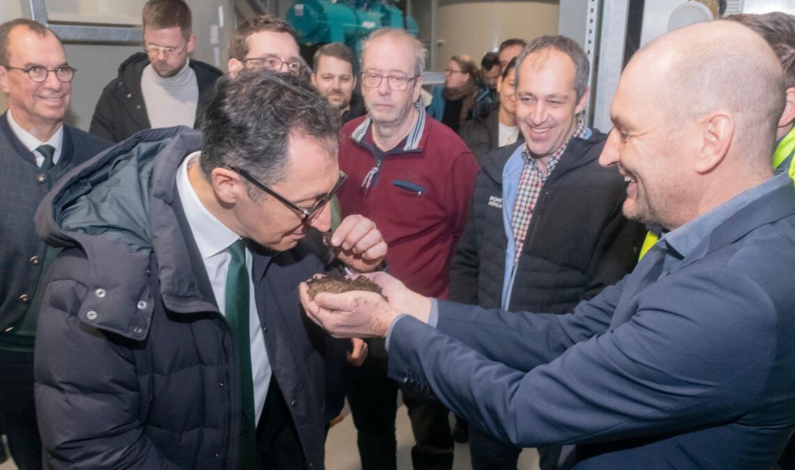 Innovation, die man riechen kann: Stadtwerke-Chef Roland Jans hält dem Spitzenkandidaten der Grünen, Cem Özdemir, Torfersatz made in Mühlacker unter die Nase. Fotos: Fotomoment