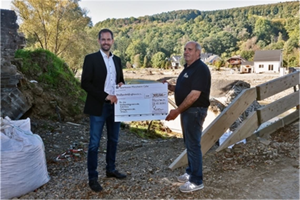 Insuls Ortsbürgermeister Ewald Neiß (re.) nimmt aus den Händen von Landrat Bastian Rosenau den symbolischen Spendenscheck entgegen. Foto: Werner Dreschers/Müsch