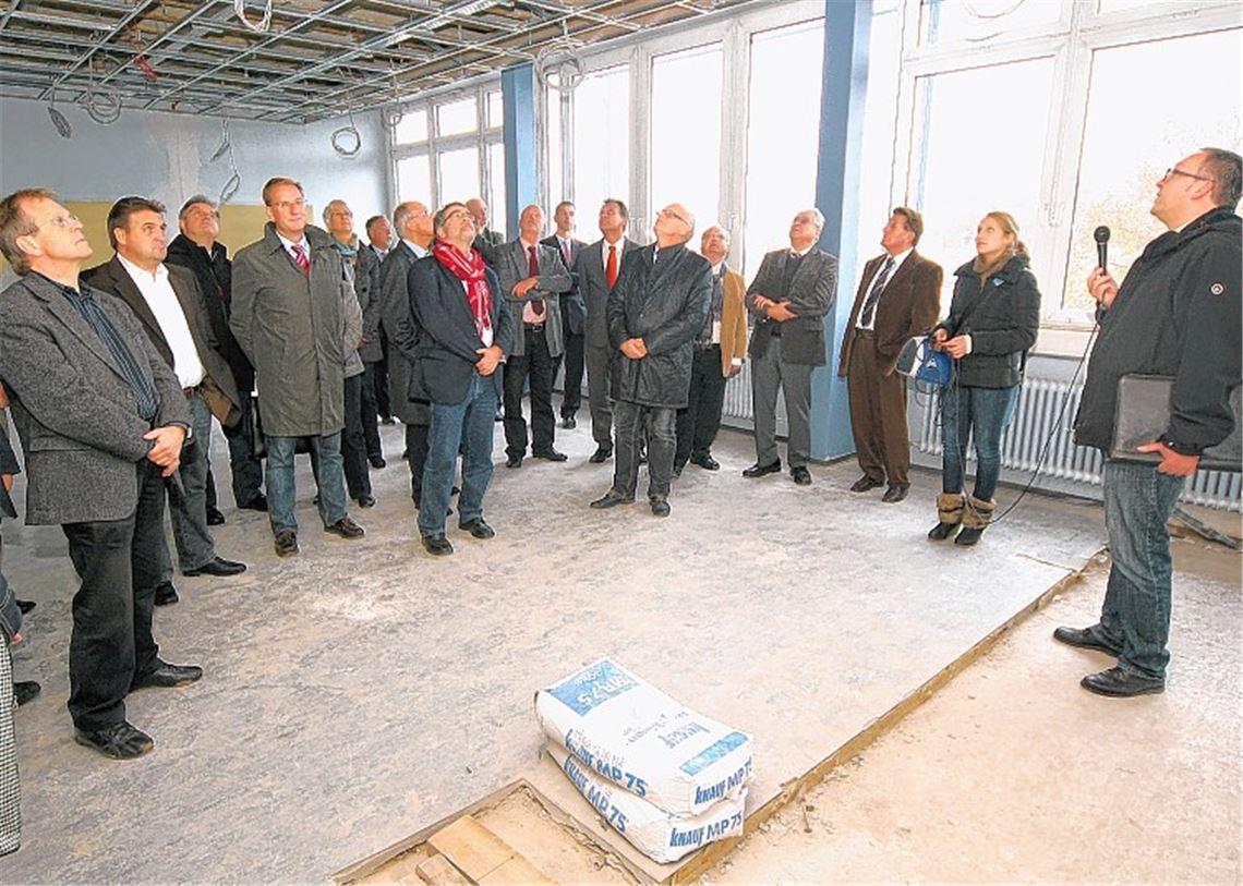 Interessierte Blicke auf die in den Rohbau-Zustand versetzten Etagen-Decken in der Steinbeis-Berufsschule in Mühlacker. Architekt Claus Lohr zeigt den Kreisräten des Verwaltungsausschusses die Sanierungsarbeiten im leerstehenden Schulgebäude. Nach der Ortsbesichtigung werden die Beratungen dort fortgesetzt, wo die Schüler während der Bauphase untergekommen sind: im Container-Provisorium auf dem Ziegeleigelände.Foto: Kollros