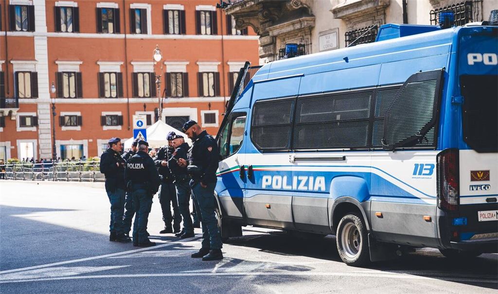 Italienische Polizisten vor einem Einsatzfahrzeug. (Symbolfoto)