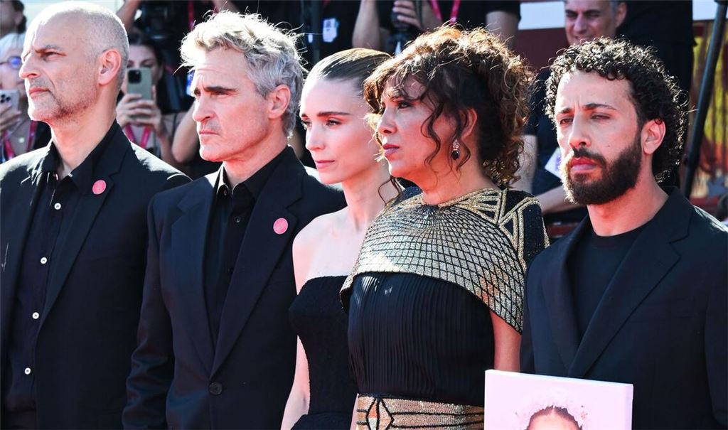 James Wilson (l-r), Joaquin Phoenix, Rooney Mara, Kaouther Ben Hania und Motaz Malhees  stehen mit einem Foto des palästinensischen Mädchens Hind Rajab auf dem roten Teppich für den Film «The Voice of Hind Rajab» während der 82. Ausgabe der Filmfestspiele von Venedig.