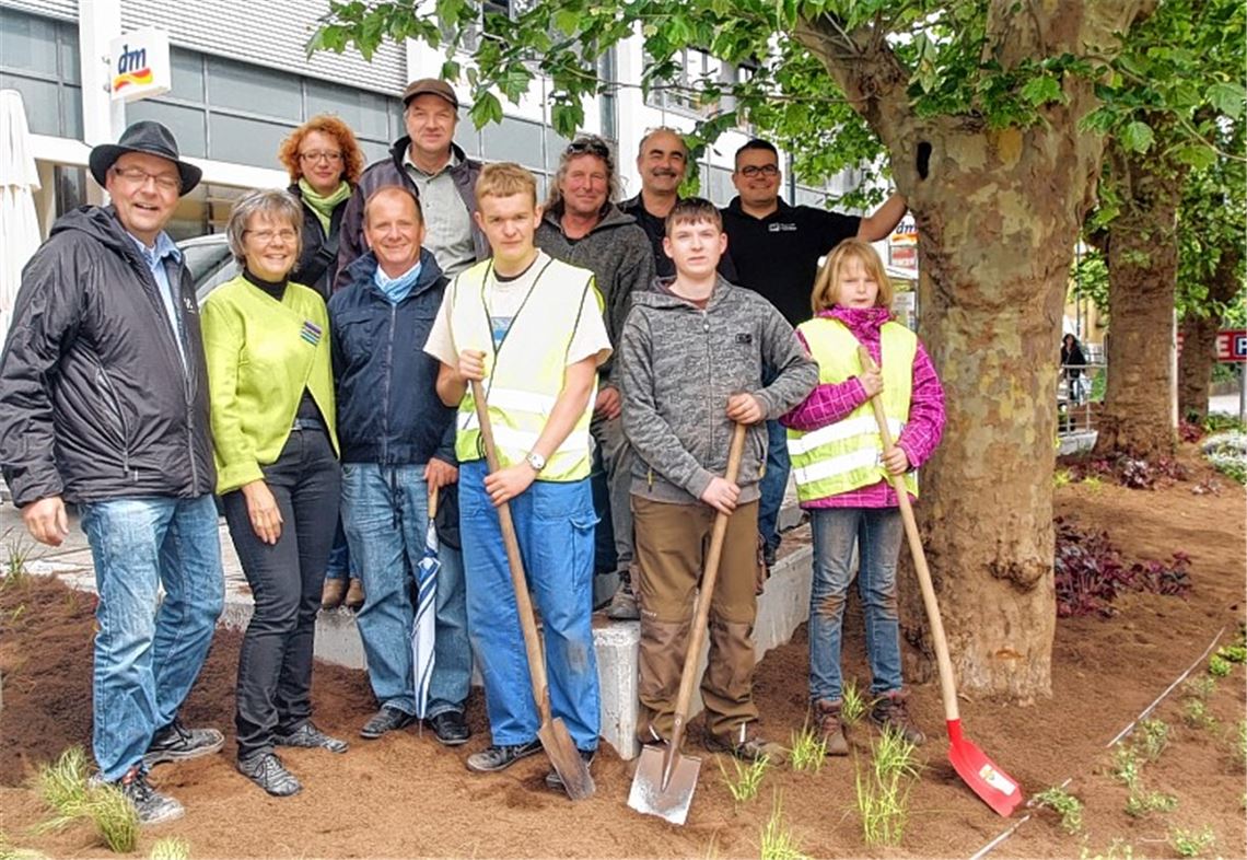 Jessica Müller, Manuel Schmid und Sebastian Blechinger (vorne, v. re.) von der Uhlandschule helfen beim Bepflanzen einer neuer Grünfläche, die vom Arbeitskreis Grüne Branche und der Stadt Mühlacker gemeinsam auf den Weg gebracht wurde.