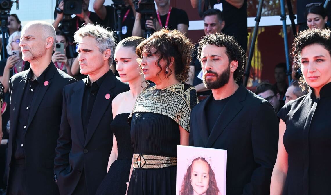 Joaquin Phoenix und Rooney Mara mit einem Teil des Filmteams und einem Foto von Hind Rajab auf dem roten Teppich.