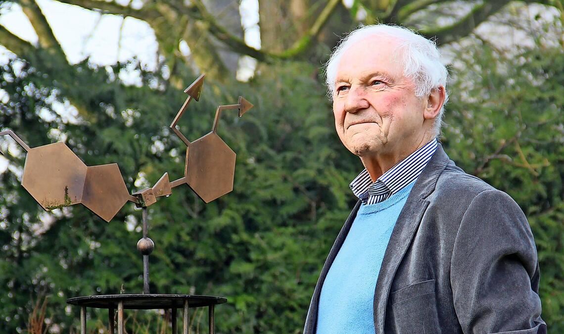 Jörg Senn-Bilfinger in seinem Garten. In dem Metallgebilde ist die Formel für das Mittel Pantoprazol verewigt.