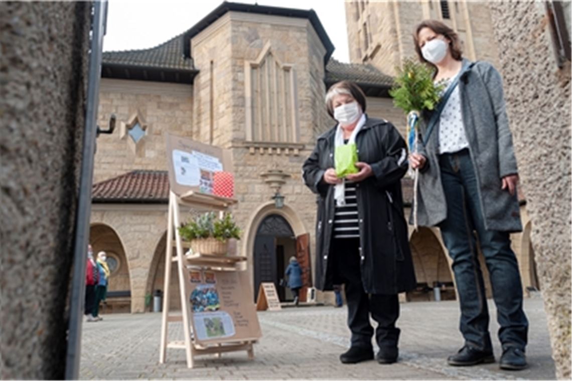 Johanna Herzig (li.) und Renate Werth von der katholischen Frauengruppe setzen mit ihren Ostertüten und einem Palmzweig ein österliches Glaubenszeichen.Fotomoment