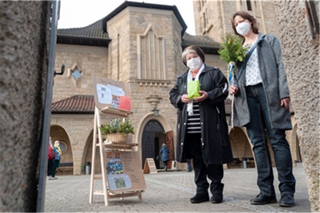Johanna Herzig (li.) und Renate Werth von der katholischen Frauengruppe setzen mit ihren Ostertüten und einem Palmzweig ein österliches Glaubenszeichen.Fotomoment