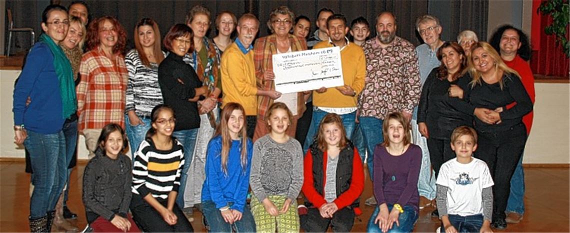 Johannes Bastian und Ursula Schaier von der Bürgerstiftung übergeben den Scheck ab Hasan Özer, der ihn stellvertretend entgegennimmt. Rechts daneben steht Theaterpädagoge Ralf Puhane, der für die Theaterarbeit verantwortlich ist.