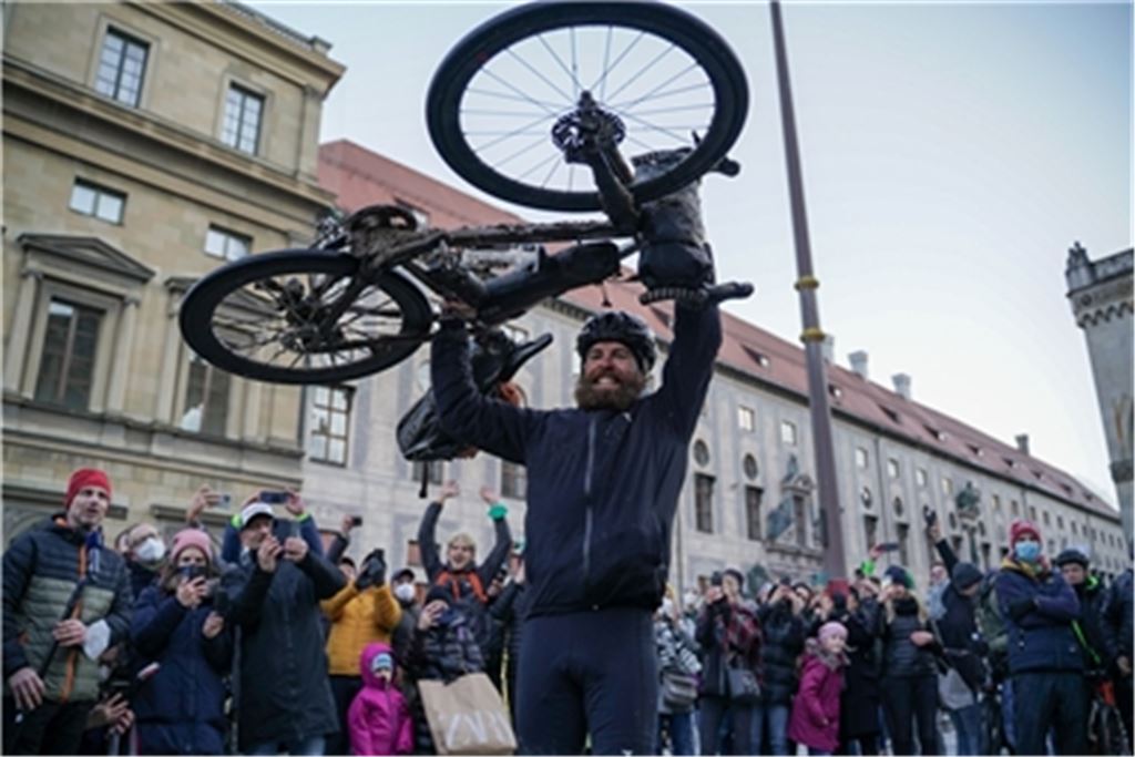 Jonas Deichmann wird auf dem Münchener Odeonsplatz, wo er 429 Tage zuvor zum Triathlon um die Welt aufgebrochen war, empfangen. Fotos: Pheline Hanke, Markus Weinberg, Andrej Bavchenkov, privat