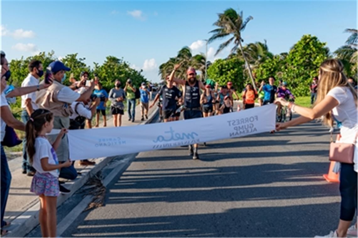 Jonas Deichmann wird von vielen einheimischen Läufern begleitet, als er in Cancun ins Ziel kommt. Foto: M. Weinberg
