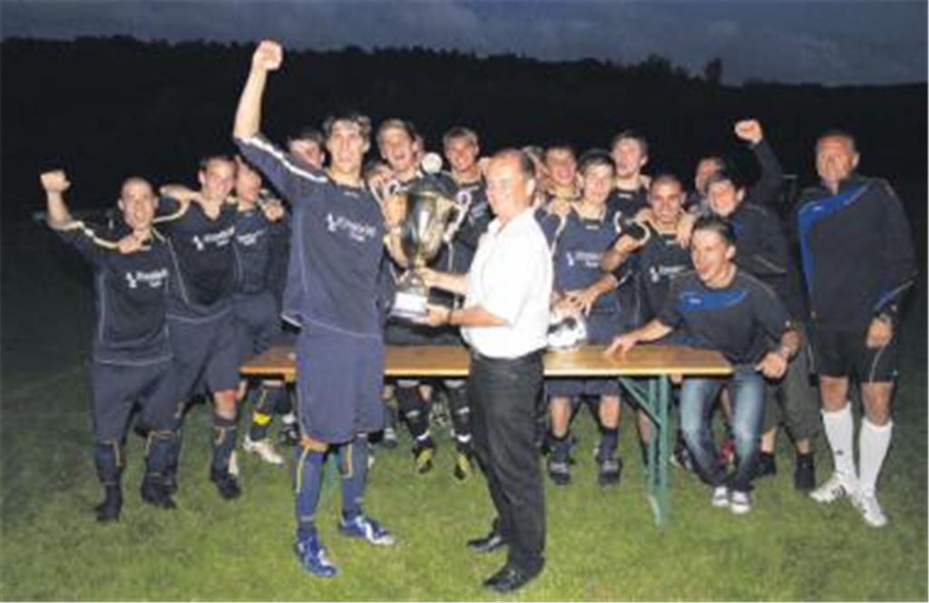 Jubel bei der Mannschaft von Phönix Lomersheim und ihrem Trainer Eberhard Carl (re.), als Bürgermeister Winfried Abicht den großen Pott überreicht.
Foto: Gössele