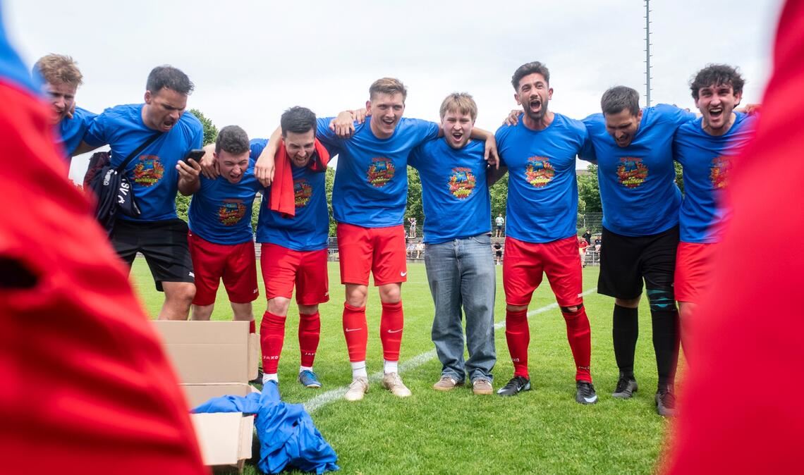 Jubel in Meister-Shirts: Die Ötisheimer freuen sich auf dem Rasen über den Aufstieg in die Kreisklasse A1 – und feiern später auf dem Vereinsgelände weiter. Foto: Fotomoment