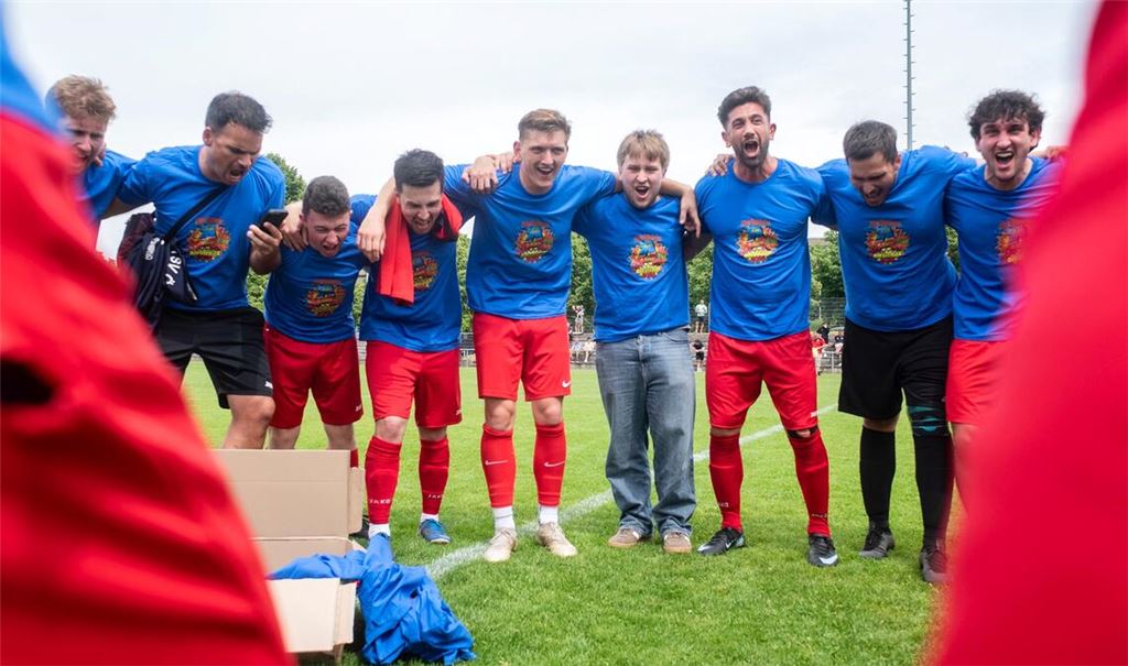 Jubel in Meister-Shirts: Die Ötisheimer freuen sich auf dem Rasen über den Aufstieg in die Kreisklasse A1 – und feiern später auf dem Vereinsgelände weiter. Foto: Fotomoment