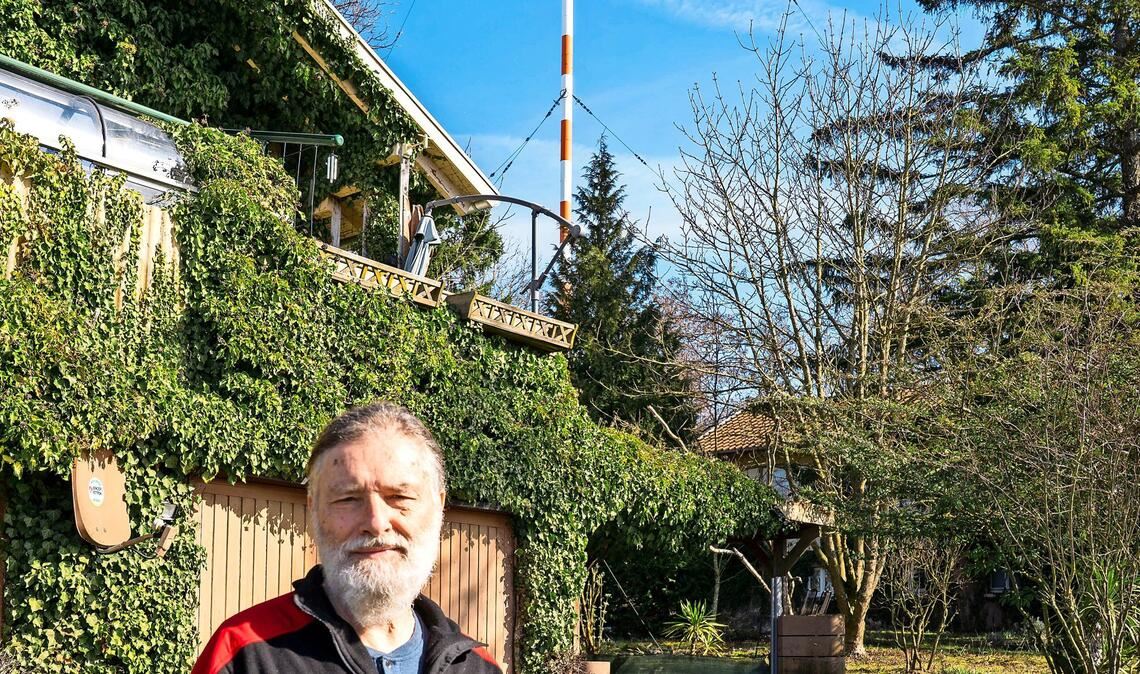 Jürgen Fegert vor seinem Holzhäuschen und dem 273 Meter hohen Sendemasten – fast 40 Jahre lebt er hier.