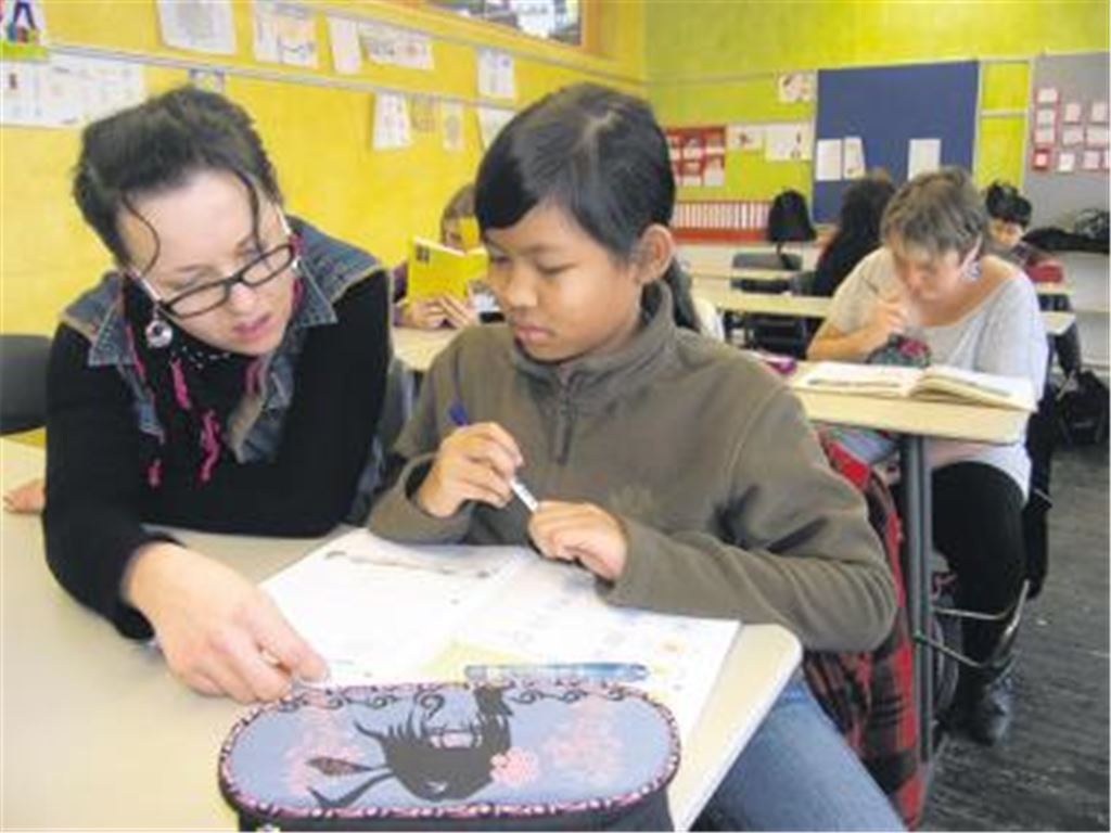 Jugendbegleiterin Mandy Schulz unterstützt Fünftklässlerin Araya bei den Hausaufgaben. Da werden für den Deutschunterricht auch lange Vokale in kurzer Zeit richtig eingetragen. Foto: Becker
