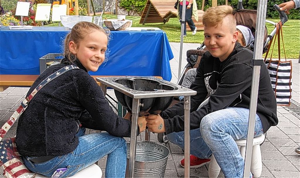 Jule und Nico haben Spaß dabei, das Melken an einem Modell zu üben. Leni (rechtes Bild li.) und Sophie präsentieren stolz ihre ausgemalten Tischset-Bilder. Fotos: Sadler