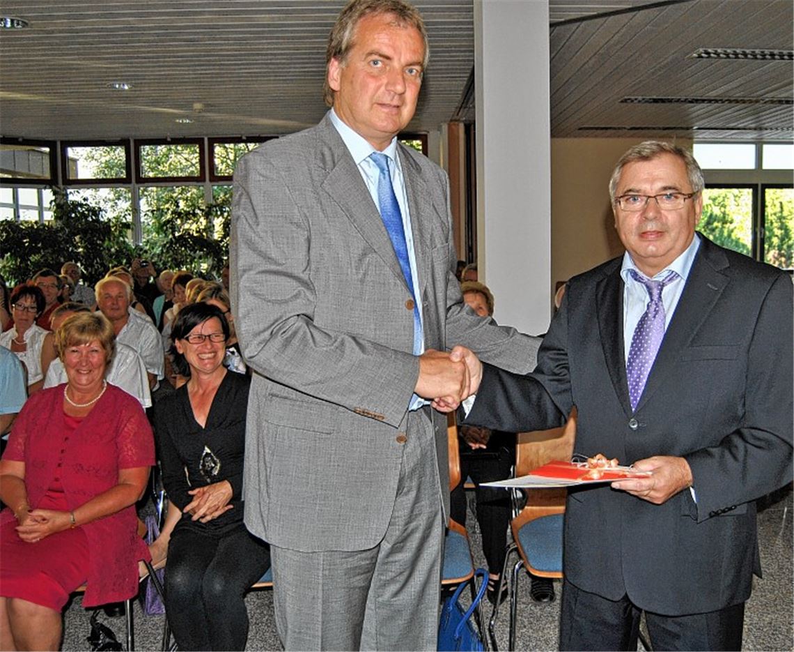 Kämmerer Manfred Dannecker (re.) wird nach 48-jähriger Tätigkeit im öffentlichen Dienst, davon 46 Jahre bei der Stadt Knittlingen, von Bürgermeister Heinz-Peter Hopp verabschiedet. Im Hintergrund links: die Ehefrauen Marion Dannecker und Susanne Hopp. Foto: Haller
