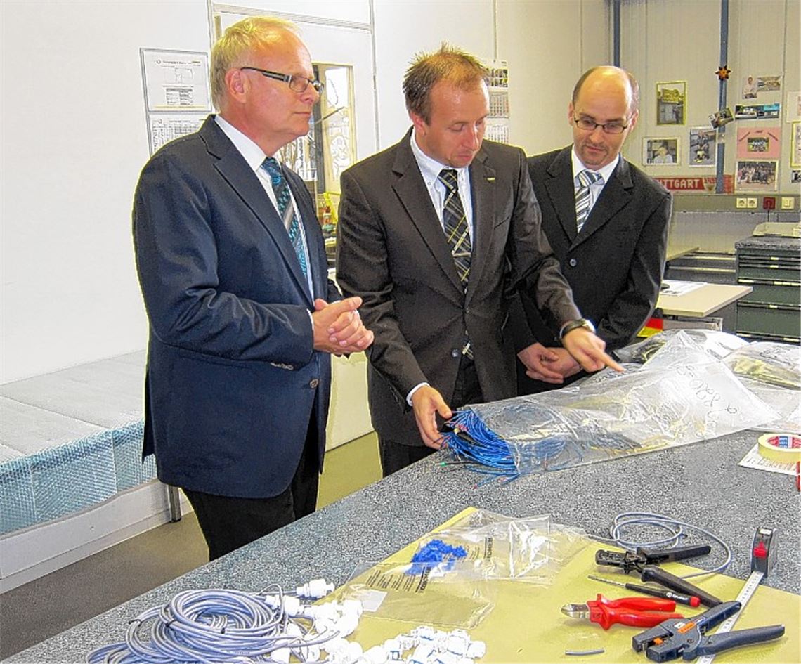 Kärcher-Werkleiter Stephan Steeb (Mitte) erläutert Landrat Karl Röckinger (li.) und Bürgermeister Harald Eiberger die Produktion von Kabelbäumen und Schaltschränken. Foto: privat
