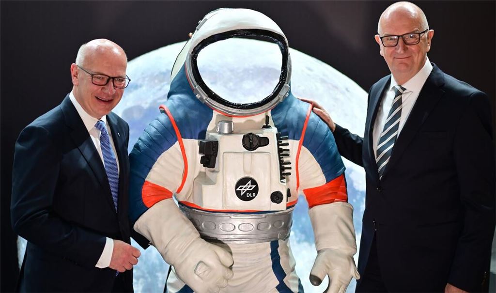 Kai Wegner (l, CDU), Regierender Bürgermeister von Berlin, und Dietmar Woidke (SPD), Ministerpräsident von Brandenburg, stehen neben einem Modell eines Weltraumanzuges.