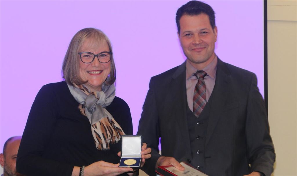 Karin Bohn-Abt erhält von Bürgermeister Treut die Verdienstmedaille der Stadt.