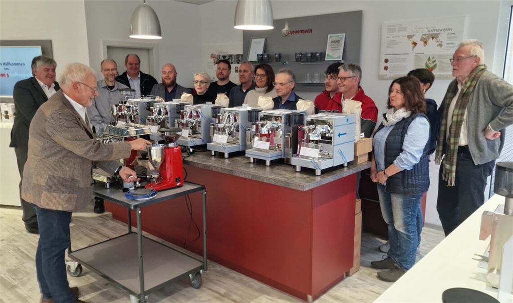 Karl Röckinger (li.) zeigt den Vertreterinnen und Vertretern von sechs gemeinnützigen Organisationen, mit welchen Tricks sie den perfekten Espresso machen können. Foto: Friedrich