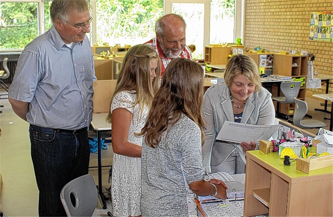 Katja Mast mit dem Schulleiter Andreas Petermann (li.) und Gemeinderat Klaus-Rüdiger Kluge bei einer Führung von zwei Schülerinnen durch ihr Lernatelier.