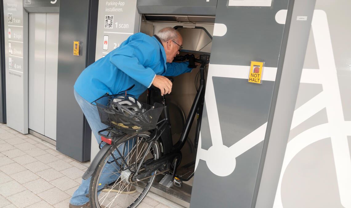 Kein Einzelfall: Rolf Czudzowitz versucht sein Fahrrad in das Fahrradparkhaus am Mühlacker Bahnhof einzustellen, aber es ist zu groß. Foto: Fotomoment