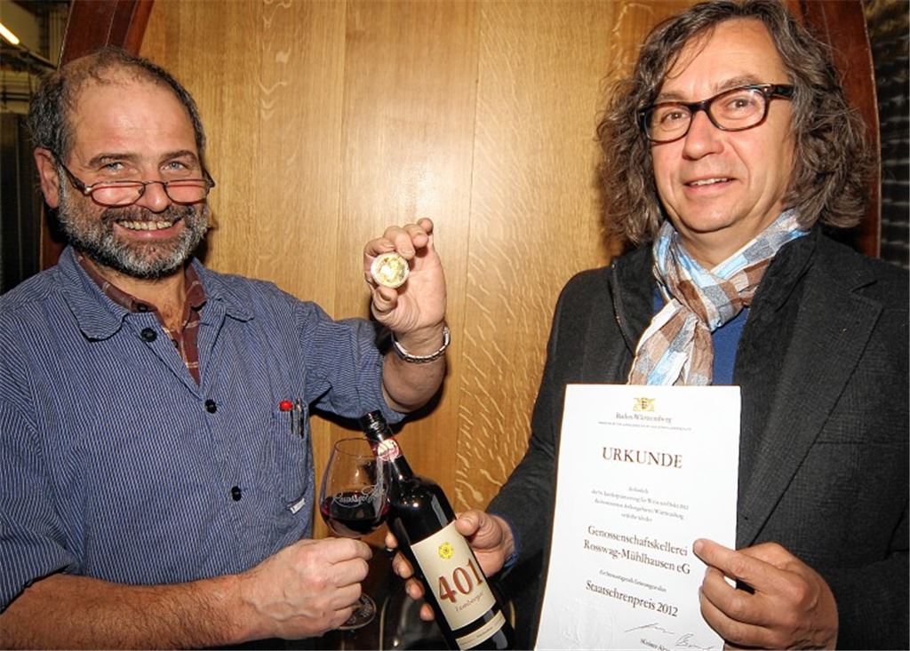 Kellermeister Jürgen Essig (li.) und Geschäftsführer Bertram Haak vor großem Holzfass: „Der Staatsehrenpreis hat uns in unserer Sammlung noch gefehlt“, meinen sie. Foto: Kollros