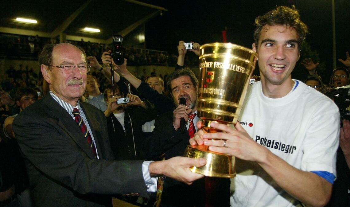 Kickers-Kapitän Jens Härter erhält 2006 den WFV-Pokal aus den Händen von Verbandspräsident Herbert Rösch.