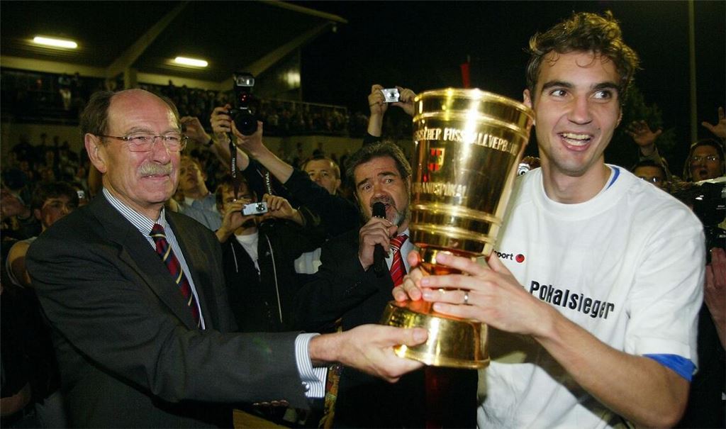 Kickers-Kapitän Jens Härter erhält 2006 den WFV-Pokal aus den Händen von Verbandspräsident Herbert Rösch.