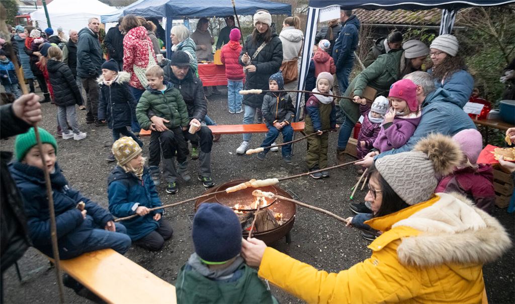 Kinder backen auf dem Lomersheimer Adventsmarkt Stockbrot. Foto: Fotomoment