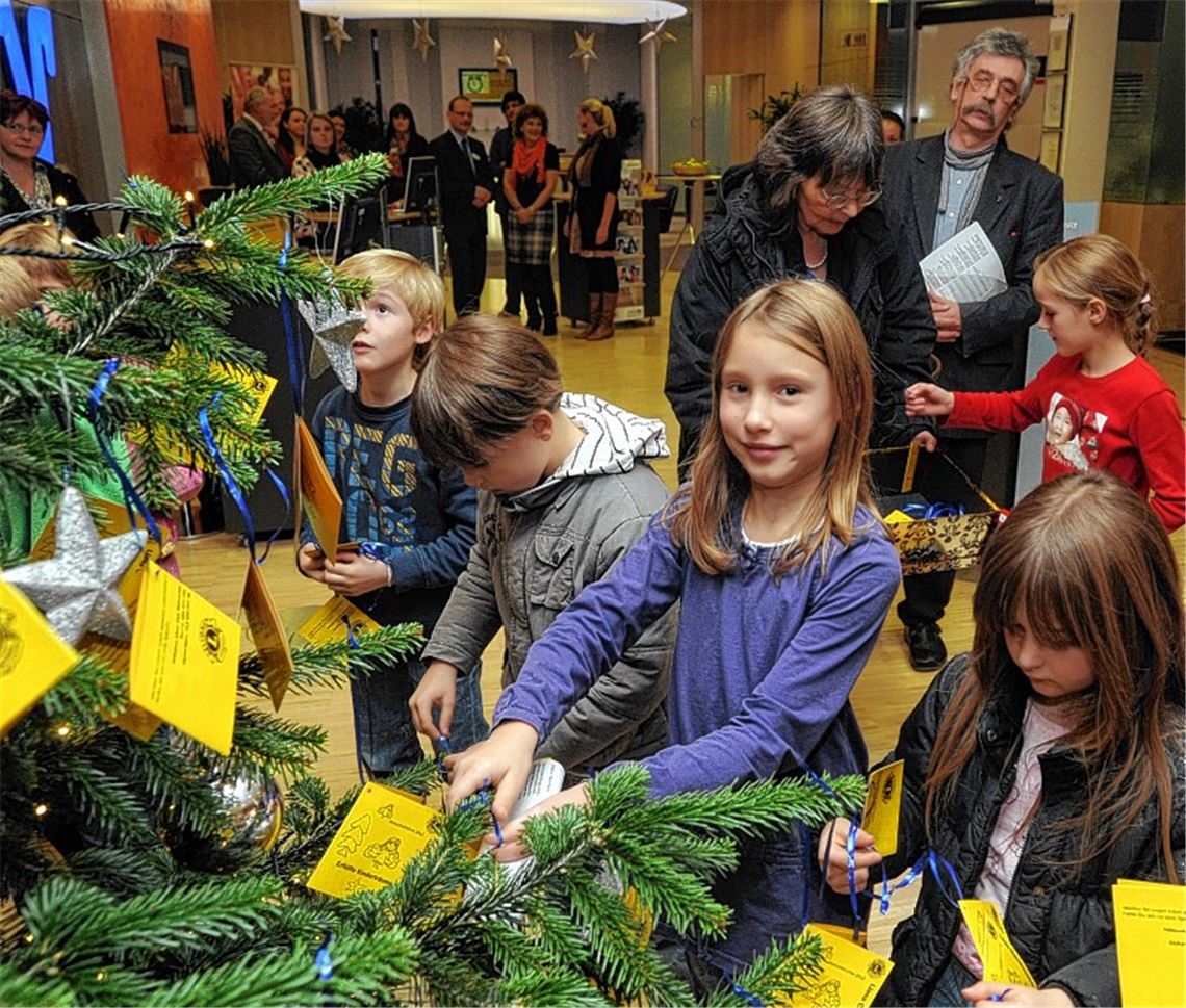 Kinder helfen beim Aufhängen der Kärtchen. Die Organisatoren freuen sich darüber, dass das Projekt längst den Status „etabliert“ für sich beanspruchen kann. „Wir haben viele ,Stammschenkende‘, die sich schon im Vorfeld nach der Aktion erkundigt haben“, berichtet Sandra Sailer.