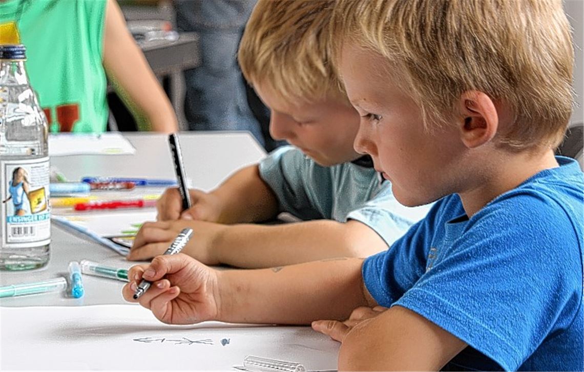 Kinder malen sich ihren neuen Spielplatz auf dem Gartenschaugelände. 