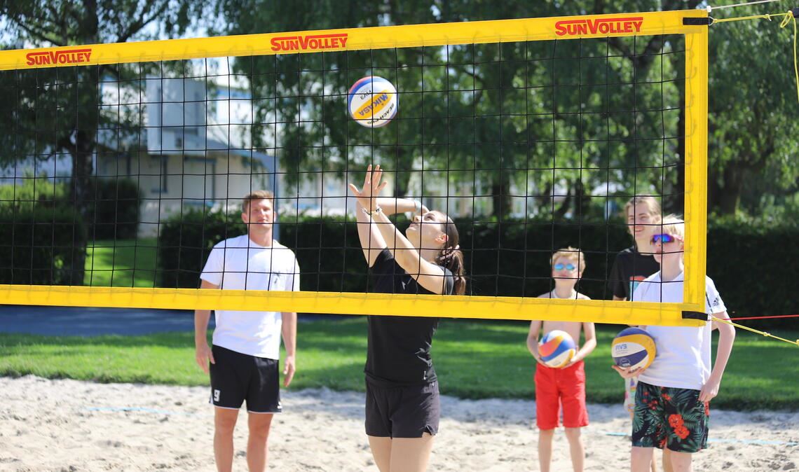 Kinder und Jugendliche haben Spaß am Beachvolleyball im Freibad Mühlacker. 
