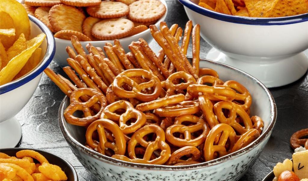 Kindersnacks locken mit bunten Verpackungen und ansprechenden Namen, enthalten aber oft mehr Salz, als gedacht (Symbolfoto).