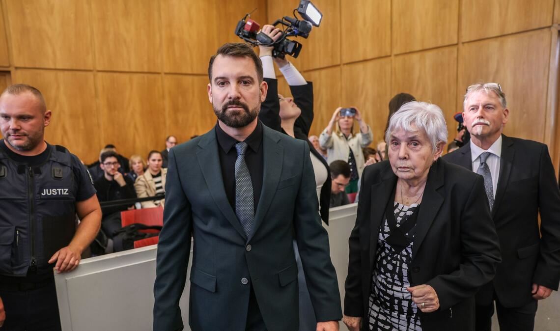 Klägerin Rita M. kommt mit ihrem Anwalt Daniel Kuhlmann (links) und dem zweiten Kläger Joachim Alfred Wagner (rechts) in den Gerichtssaal.