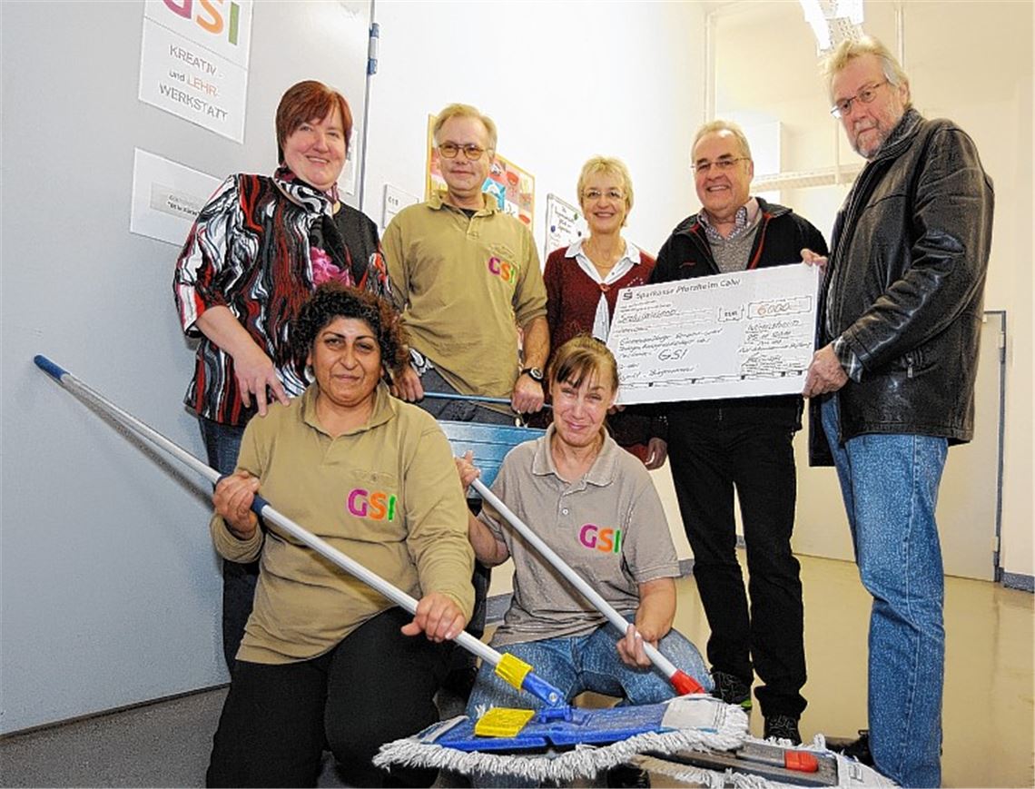 Klaus-Peter Böhringer übergibt die Spende an Gerd Schulz (hintere Reihe v. re.), Andrea Lang, Horst Baumann (hintere Reihe v. li.), Arselus Biyikli, Margit Wohlfahrt (vorne v. li.) von der GSI und an Isolde Renner-Rosentreter von der Diakonischen Bezirksstelle.