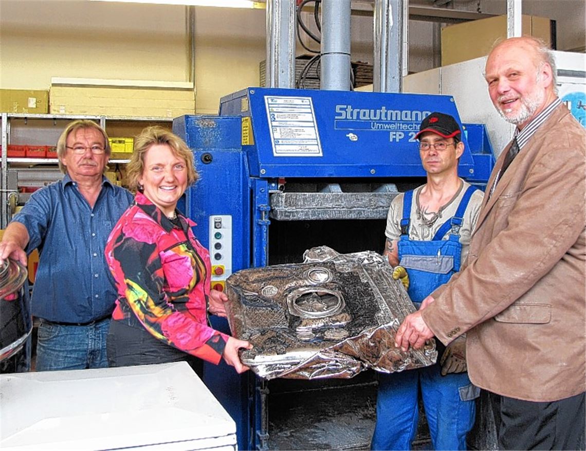 Klaus Rieger, Elektrikermeister und Leiter des Fachbereichs Metallrecycling (li.), und Mitarbeiter Torsten Leise zeigen Katja Mast die Metallpresse. Mit dabei: Roland Hübner, Sozialdezernent des Enzkreises (re.).