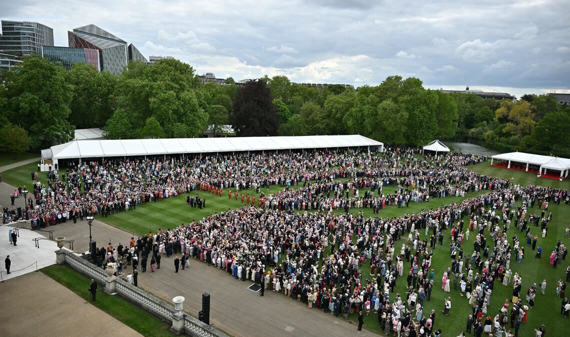König Charles III. und Königin Camilla (unten links) stehen vor dem Beginn einer königlichen Gartenparty im Buckingham Palace, London, an der Spitze der Gartentreppe.