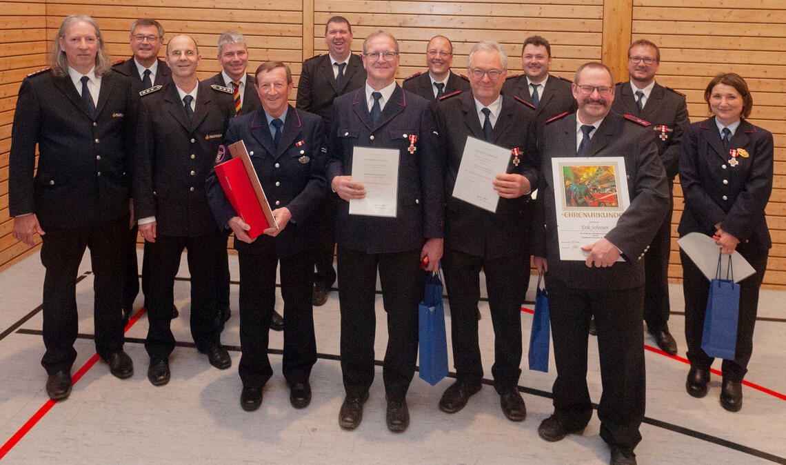 Kommandant Ralph Küppers, Michael Gutjahr als Sprecher des Kreisfeuerwehrverbands, der stellvertretende Kreisbrandmeister Martin Irion und Bürgermeister Matthias Enz (v.li.) ehren unter anderem Erik Schröter, Thomas Gille, Frank Bäuerle und Ludwig Gille (vorne v.re.) für 40- bis 60-jährige Zugehörigkeit zur Wiernsheimer Feuerwehr. Foto: Fotomoment